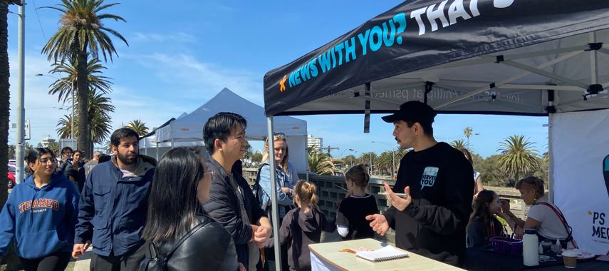 Reporter Peter Quattrocelli talking to people at PS Media stall at St Kilda's Esplanade Market on Sunday September 25 2022. Pic by Aditya Dhawan